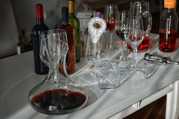 Decanter with red wine and glasses on table against blurred background