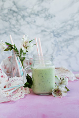 Breakfast smoothie of kiwi and milk on light background