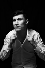 Low key portrait of a man in white shirt in black and white.