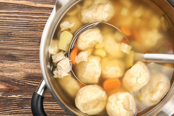 Pan with delicious chicken and dumplings on wooden table