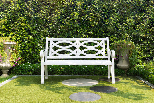 White Wood Bench Chair With Bush Background In Garden At Home.