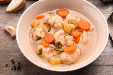 Bowl of delicious chicken and dumplings on wooden dining table