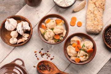 Portions of delicious chicken and dumplings on dining table