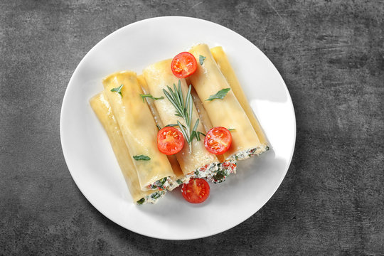 Delicious stuffed cannelloni with cherry tomatoes on plate