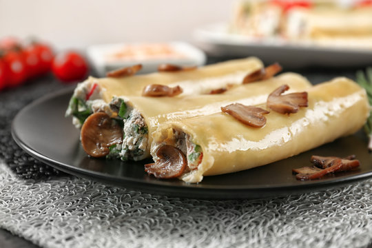 Delicious stuffed cannelloni with mushrooms on plate