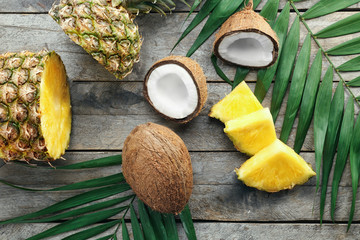 Composition of fresh pineapple and coconuts on wooden background
