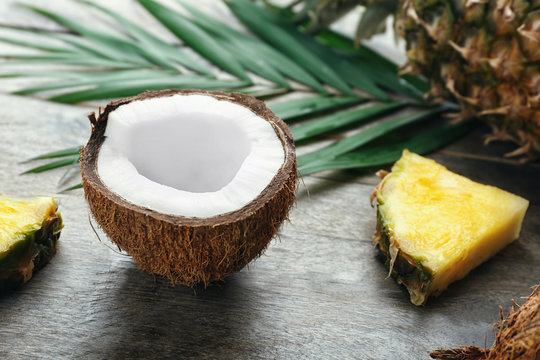 Fresh coconut and pineapple slices on wooden background