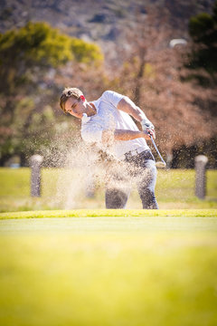 Close up image of a golfer playing a chip shot onto the green on a golf course in south africa.