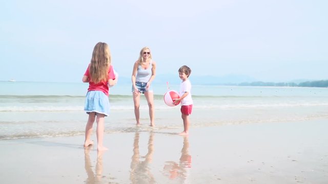 kinder und mutter spielen mit buntem wasserball auf einem sch&ouml;nen sandstrand in thailand