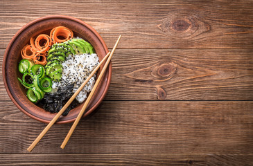 Sushi bowl with seaweed, avocado,  radishes, cucumber and black sesame seeds.