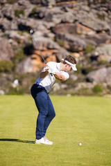 Close up image of a male golfer playing a shot on the fairway on a golf course in south africa.