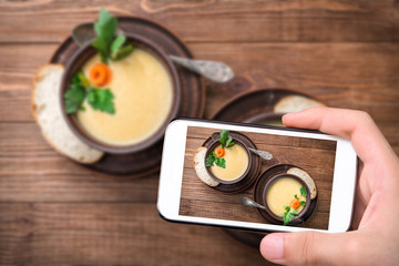 Fototapeta na wymiar Hands taking photo pea soup with smartphone.