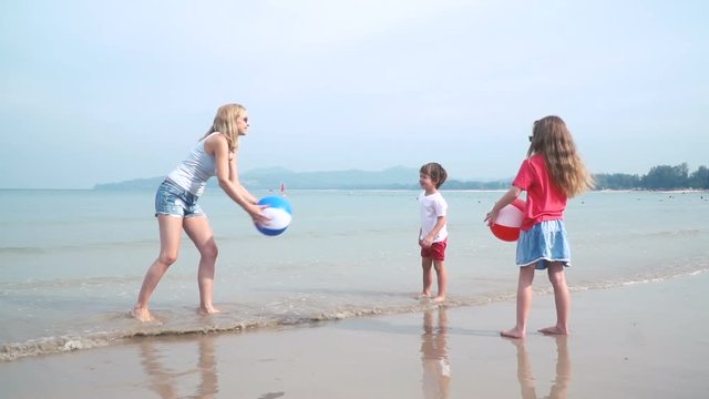 kinder und mutter spielen mit buntem wasserball auf einem sch&ouml;nen sandstrand in thailand