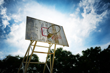 Basketball hoop and wood backboard with blue sky