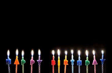 burning colorful happy birthday candles with copy space