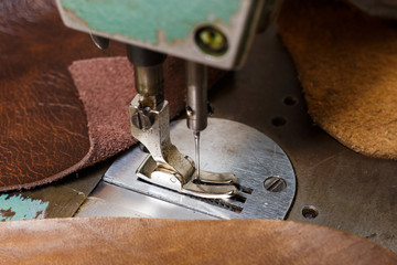 Old sewing machine and natural cow leathers. Selective focus.