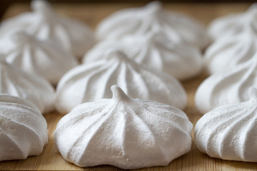 Fresh mini meringues on a wooden background. Food background