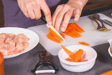 Cook cutting carrots with a ceramic knife