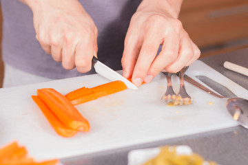 Cook cutting carrots with a ceramic knife