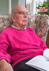 95 years old English man sitting in chair in domestic environment. Health and care concept