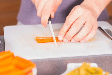 Cook cutting carrots with a ceramic knife