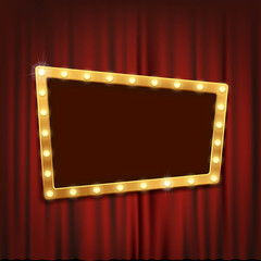 Fototapeta premium Gold frame with light bulbs on the red theatrical curtain.