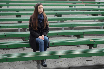 Portrait of a beautiful girl on a green bench
