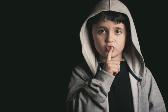 ni&ntilde;o con el dedo en los labios
