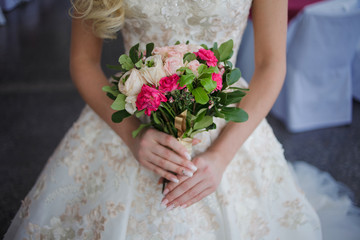 Bride's bouquet. Beautiful girl in a luxurious wedding dress holding flowers