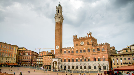 Fototapeta na wymiar Siena, Italy - September 5, 2014: The Campo Square with Mangia Tower the landmark of Siena, Italy.