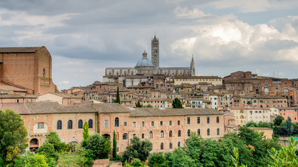 Fototapeta na wymiar Siena, Italy - September 5, 2014: The wonderful medieval city of Siena with Siena Cathedral in Tuscany region on a cloudy day