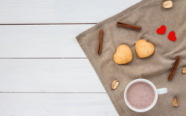 Composition with coffee, cup, cookie, cinnamon sticks on white wooden background. Flat lay