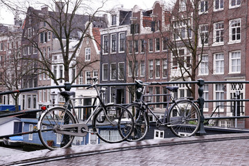 Fototapeta na wymiar two bikes on bridge in amsterdam
