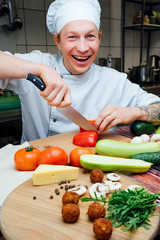 Happy vegan cook in the kitchen cuts vegetables