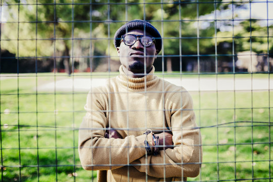 Portrait of a cool young man behind a metal net