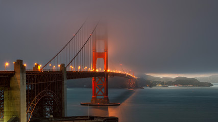 Magic hour at the Golden Gate Bridge at sunset in fog.
