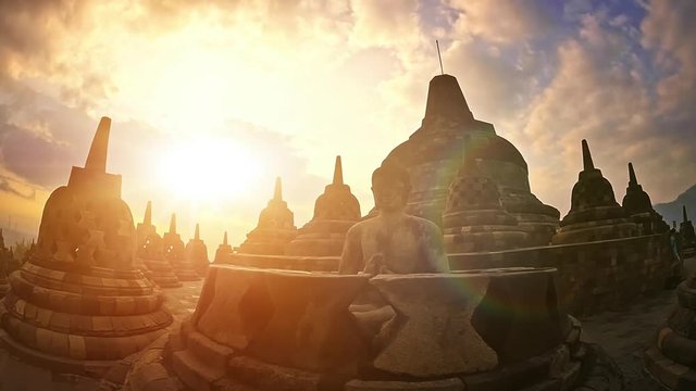 Statue of meditating Buddha ancient sculpture. Borobudur Buddhist temple sunset sky beautiful view in Java, Indonesia