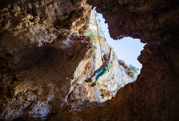 Little boy being lowered down while top rope climbing