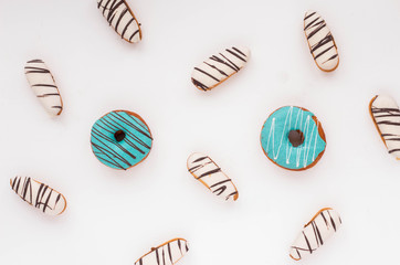 Donuts and cookies on white background. Flat lay.