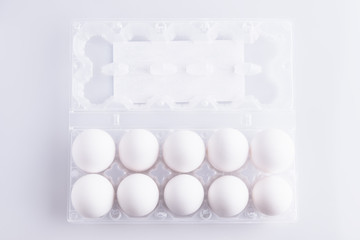 Box with white eggs on white background