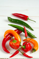 Chilli peppers mix. Orange, green and red. White background.