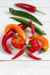 Chilli peppers mix. Orange, green and red. White background.
