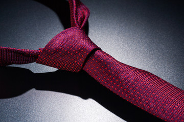 Tied red a tie on a dark table.