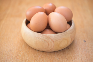 Chicken eggs in a wooden bowl