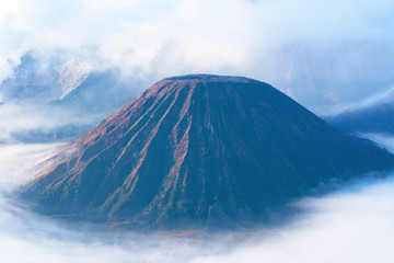Mount Bromo, an active volcano surrounded by white clouds of mist in the morning at the Tengger Semeru National Park in East Java, Indonesia.
