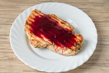 Grilled chicken schnitzel with cranberry sauce / Grilled chicken schnitzel with cranberry sauce on white plate