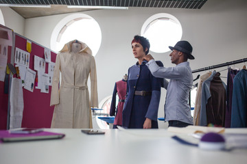 Fashion designer pinning garment on a model