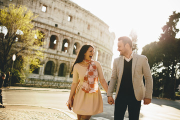 Loving couple in front of the Colosseum in Rome, Italy - obrazy, fototapety, plakaty