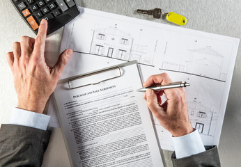 property developer hands with architect blue print writing purchase agreement