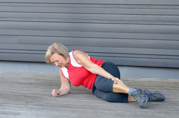 Senior woman with severe muscle cramps